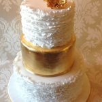 Gold leaf wedding cake with white ruffles